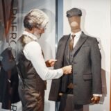 Bărbat îmbrăcat smart casual, cu blazer bleumarin, tricou alb, pantaloni chino și sneakersi albi din piele